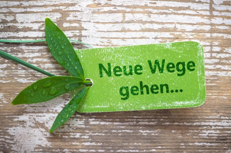 Foto eins kleinen grünen Schildes auf einem Holzbrett